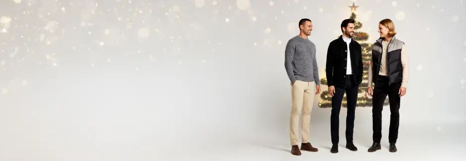 Trzech mężczyzn ubranych w stylowe, swobodne stroje stoi razem na jasnym tle, prezentując nowoczesne trendy w modzie.